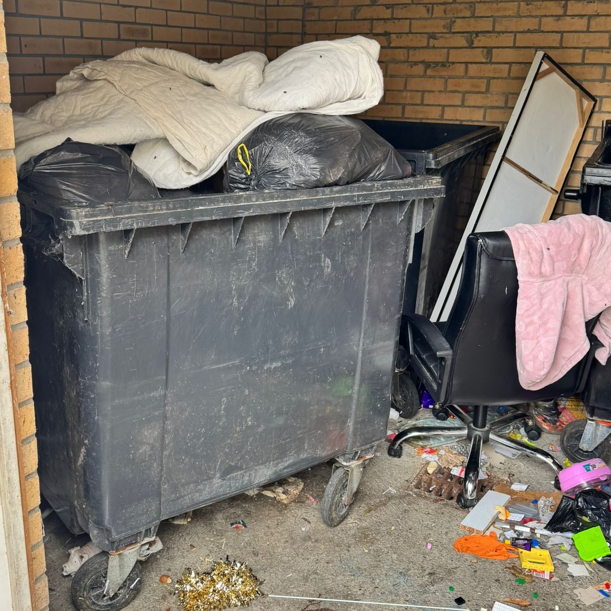 An overflowing bin and piles of rubbish 