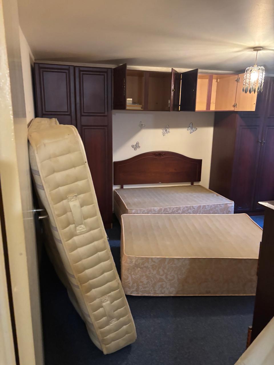 A room with furniture stacked against the wall prior to bed bug treatment